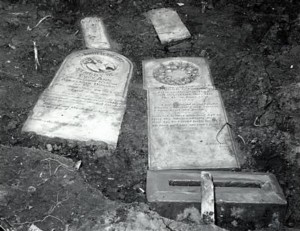 photo shows a couple of fallen gravestones