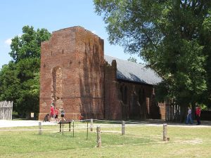 photo shows a large brick building nestled in an even larger tree